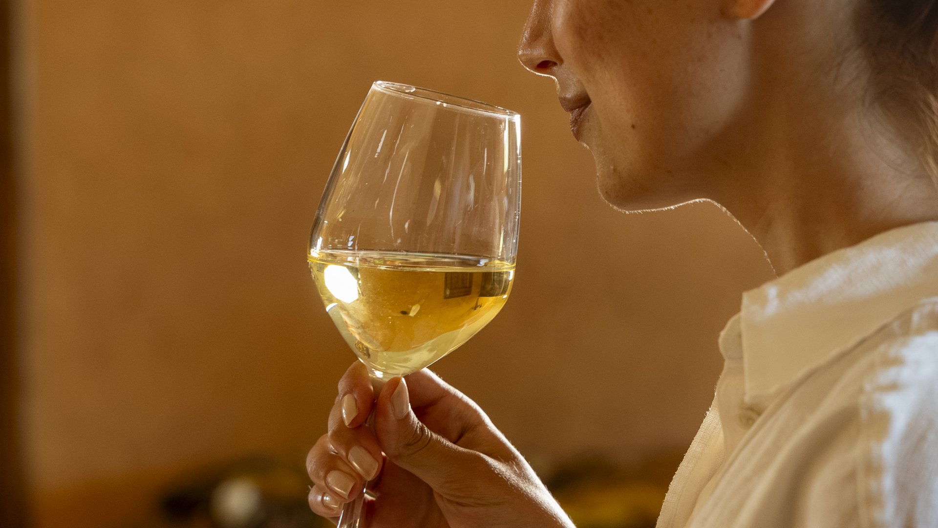 Un hotel vicino ad Assisi con mezza pensione da sogno Donna che annusa un bicchiere di vino bianco in un ambiente caldo