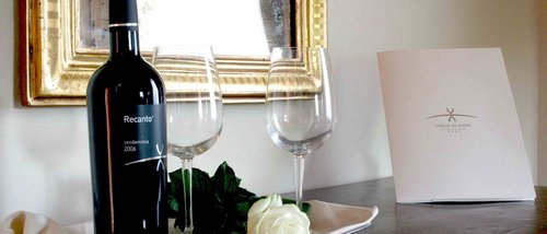 Gift Voucher Idee Regalo Festa della Mamma e anniversari dalla SPA benessere ai massaggi con cena. Bottiglia di vino rosso con due calici e rosa bianca su vassoio