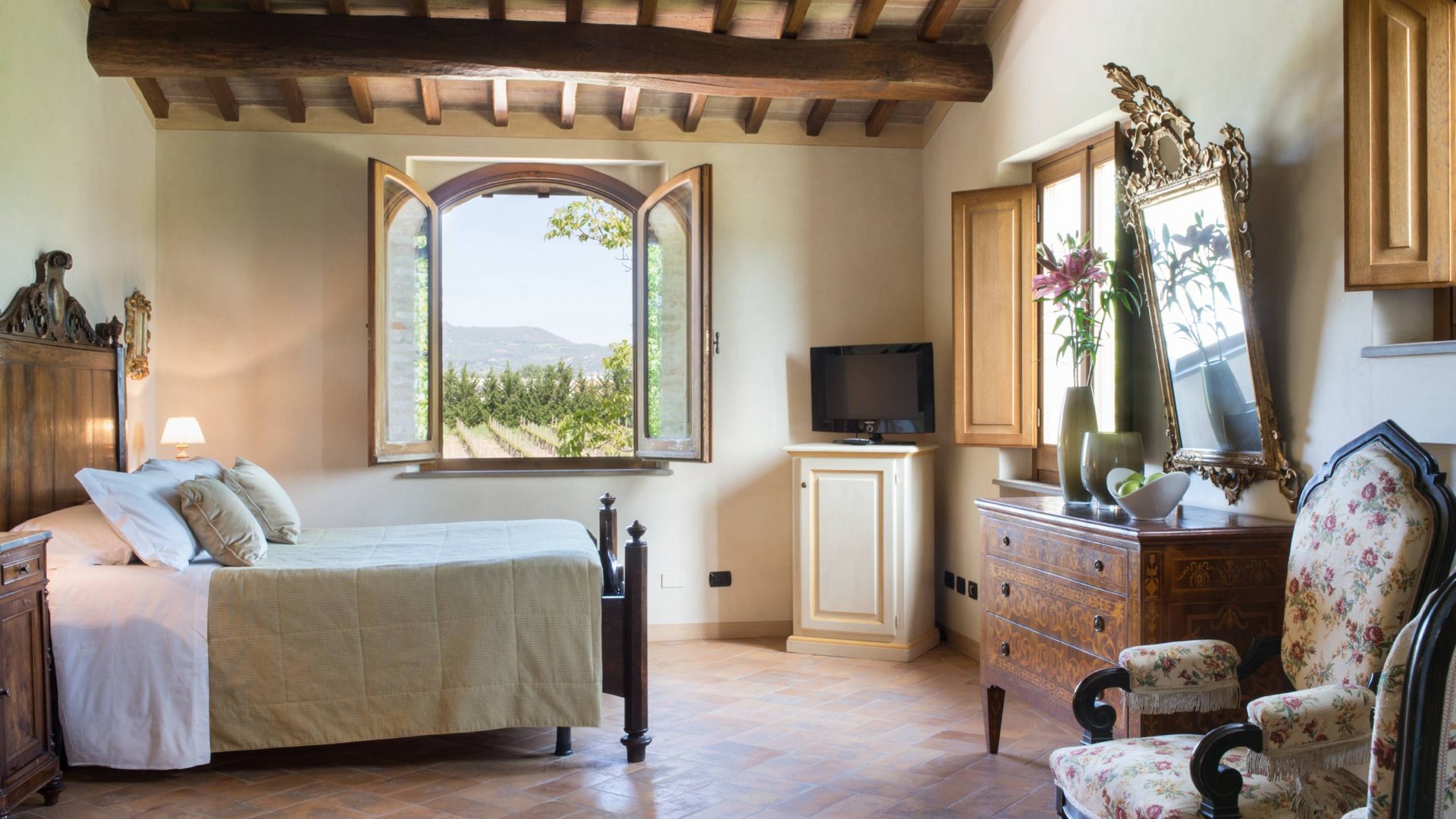 Villa ad Assisi con piscina privata, vacanze nel cuore dell'Umbria Camera da letto rustica con soffitto a travi in legno e vista sulla campagna