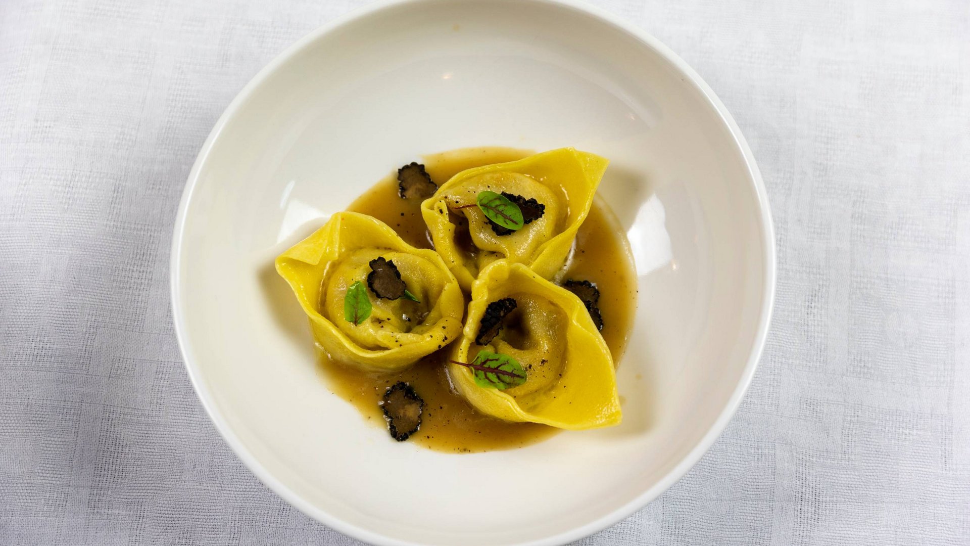 Hotel con ristorante vicino ad Assisi: benvenuti al Recanto Tre tortellini con salsa e tartufo in un piatto bianco