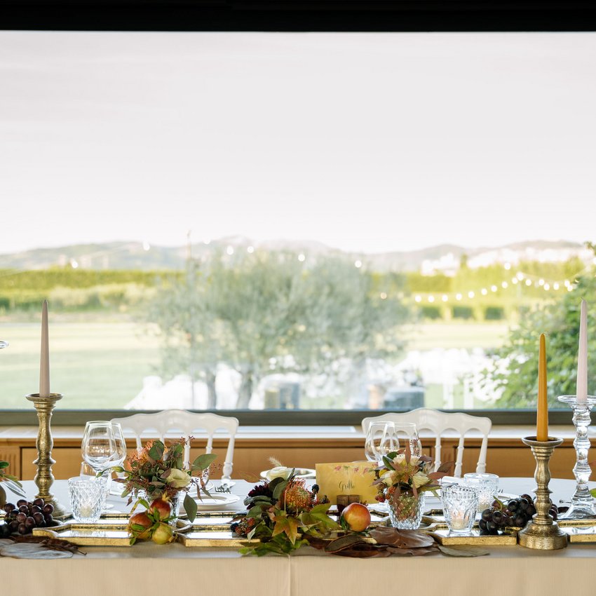 Un hotel accessibile, in Umbria, con una marcia in più Tavolo elegantemente apparecchiato con candele, fiori e frutta davanti a una finestra con vista verde