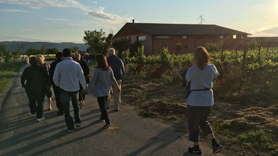Vacanza vicino ad Assisi, Resort Hotel com Campo da Padel Tennis Bike Hotel 3 piscine campo da calcetto. Gruppo di persone che camminano su una strada vicino a una casa rurale al tramonto