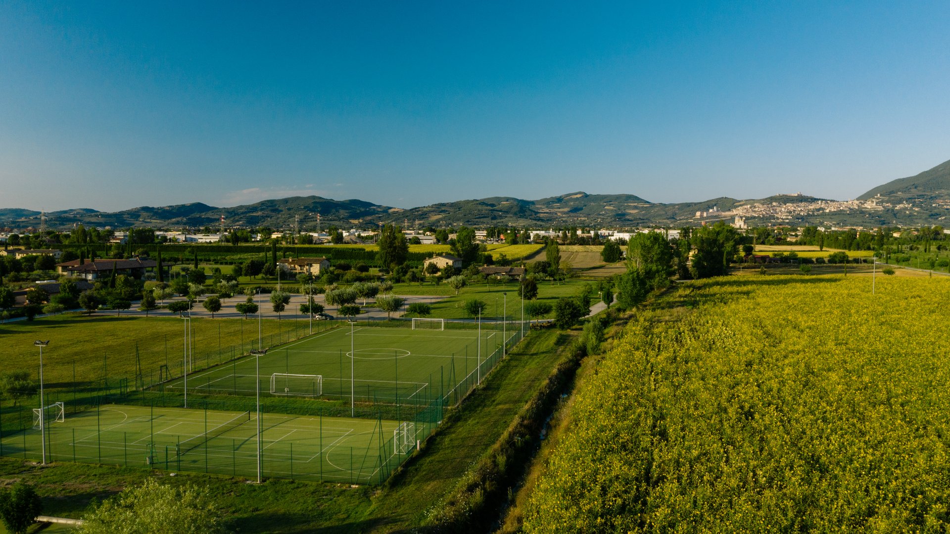Vacanze Bike ad Assisi unico Italy bike hotels in Umbria Campi da calcio verdi vicino a un campo giallo e colline sullo sfondo