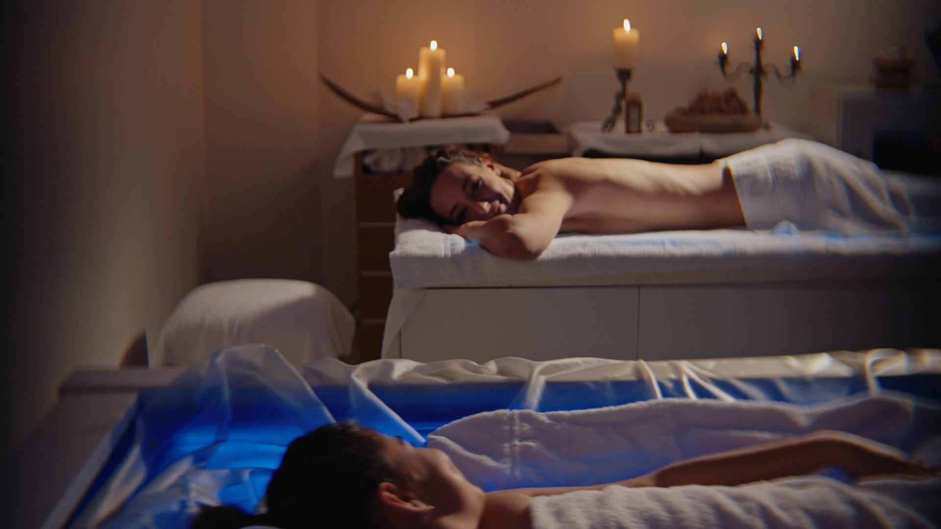 Gift Voucher Idee Regalo Festa della Mamma e anniversari dalla SPA benessere ai massaggi con cena. Due persone rilassate durante un trattamento termale in una stanza con candele accese