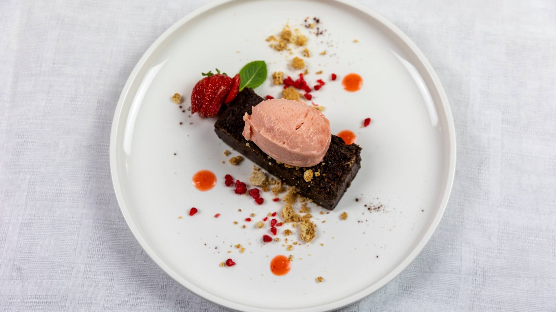 Hotel con ristorante vicino ad Assisi: benvenuti al Recanto Dessert con torta al cioccolato, gelato alla fragola e decorazioni di fragole e briciole