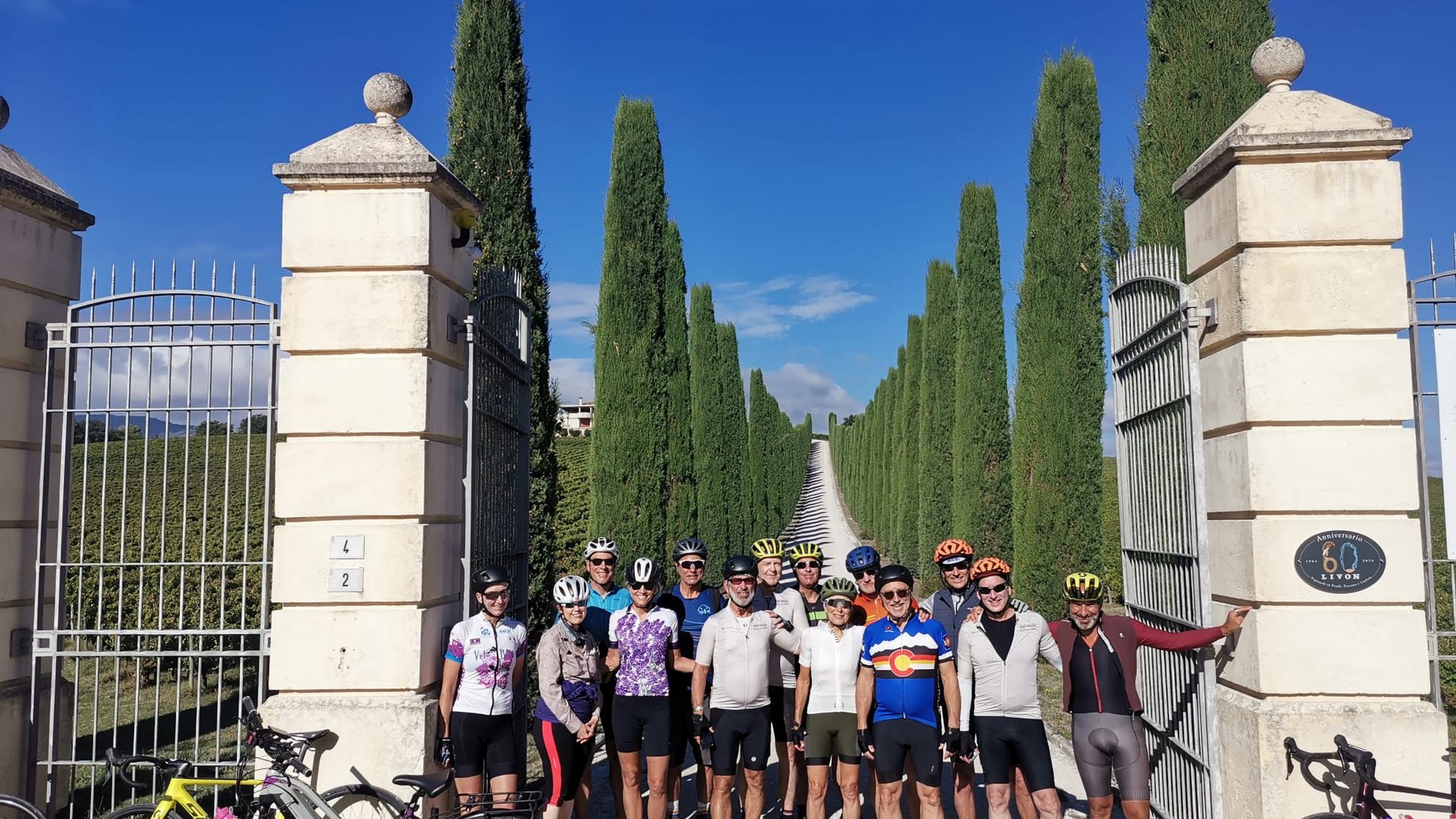 Vacanze Bike ad Assisi unico Italy bike hotels in Umbria Gruppo di ciclisti in abbigliamento sportivo davanti a un cancello con alberi alti