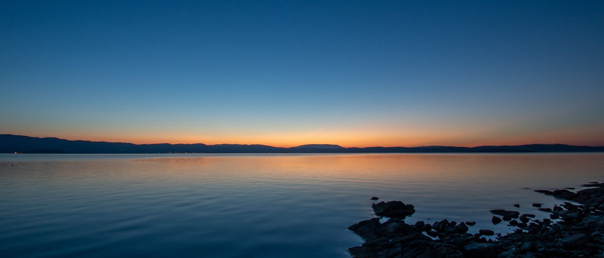 Basilica of Saint Francis of Assisi Sunset over lake with clear sky and reflections on calm water
