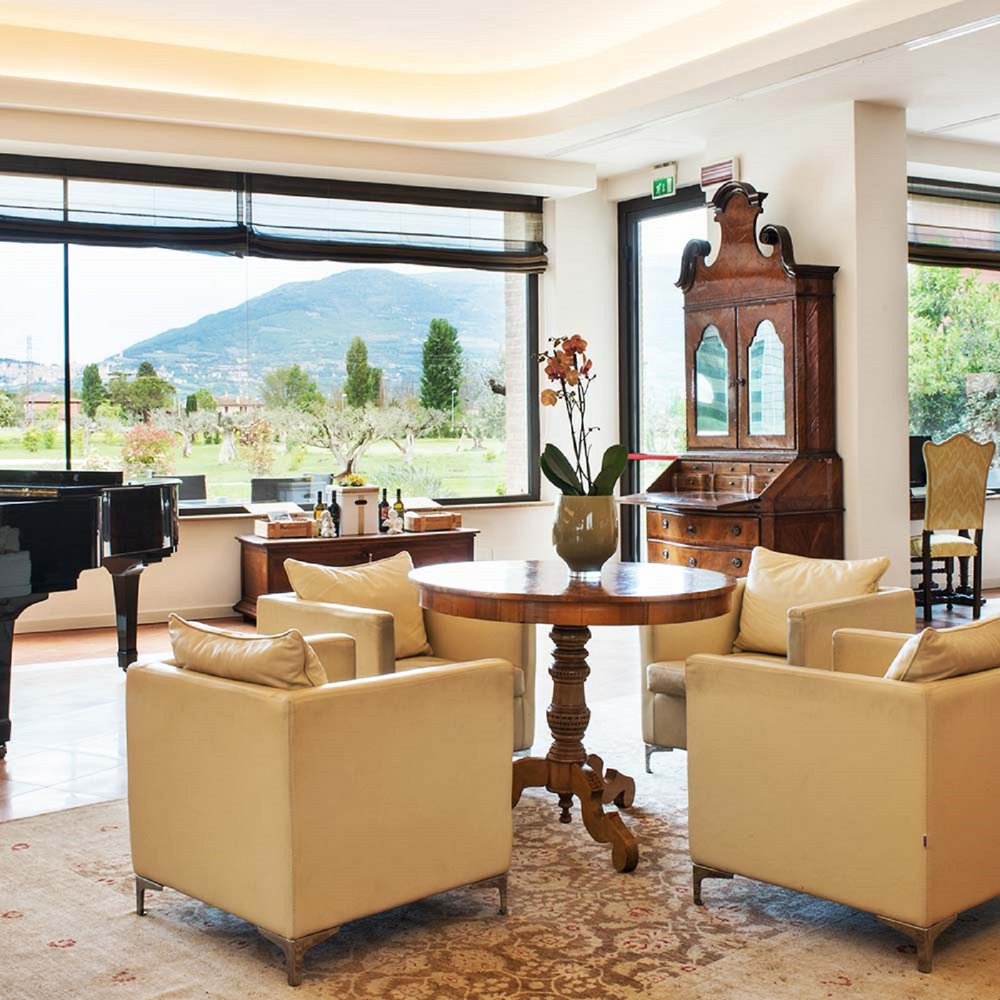 Un hotel accessibile, in Umbria, con una marcia in più Salotto elegante con pianoforte a coda e vista panoramica sulle colline