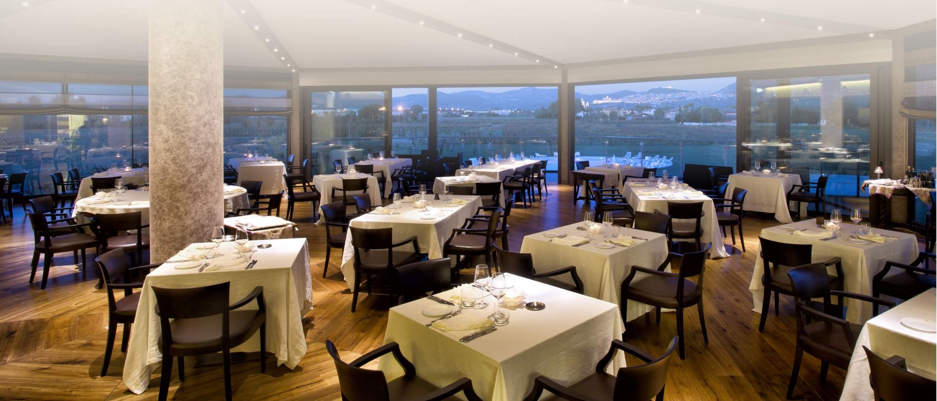 La missione di Valle di Assisi Ristorante elegante con tavoli apparecchiati e viste panoramiche
