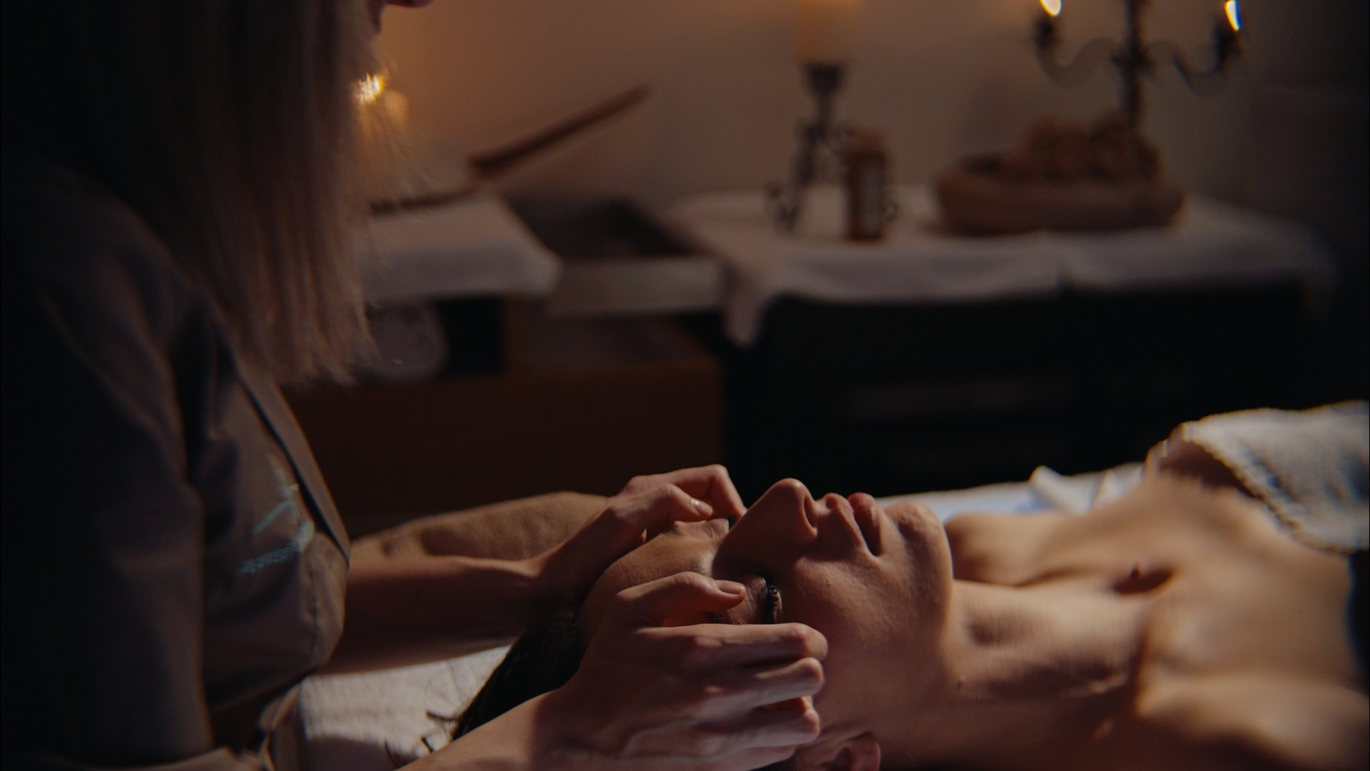 Day SPA con accesso piscina esterna a sfioro Donna che riceve massaggio facciale in ambiente rilassante con candele accese