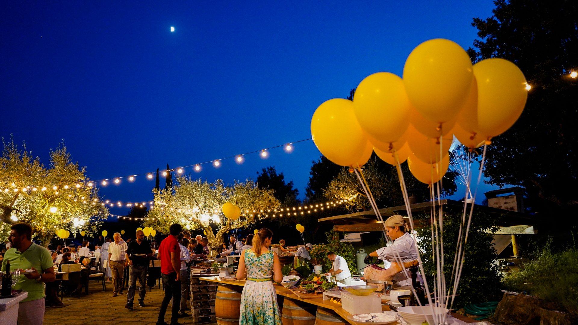 Cena Sotto le Stelle Festa serale all'aperto con palloncini gialli e luci decorative